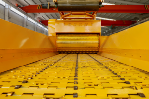 Close view of a horizontal grinder infeed conveyor and feed roller