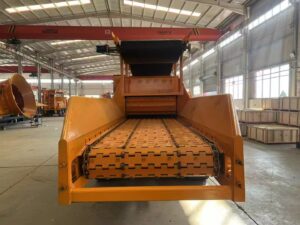 Infeed chain and feed opening of a WD1380 horizontal wood grinder inside a workshop